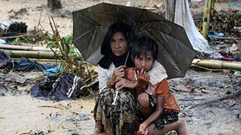 Kvinde og barn søger ly under en paraply i Bangladesh' flygtningelejr for rohingyaer Balukhali den 17. september 2017. 