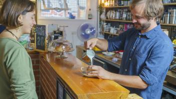 Frivillig laver kaffe på Café Mellemrummet 