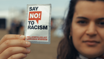 Ung kvinde med klistermærke, hvorpå der står "Say no to racism"