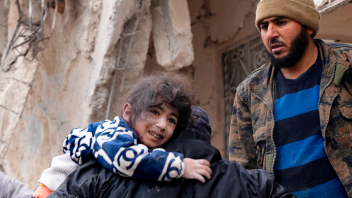 Indbyggere redder et lille barn ud af murbrokkerne efter jordskælvet i byen Jandaris, der ligger uden for Afrin i Syrien.