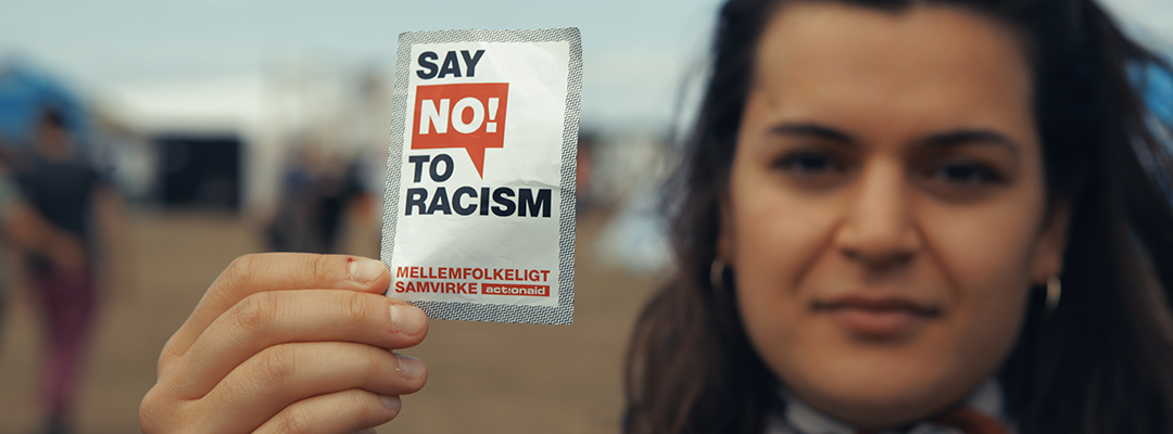 Ung kvinde med klistermærke, hvorpå der står "Say no to racism"