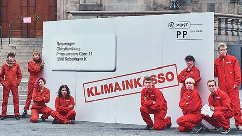 Klimainkasso-aktivister med store rodekuvert foran Christiansborg.